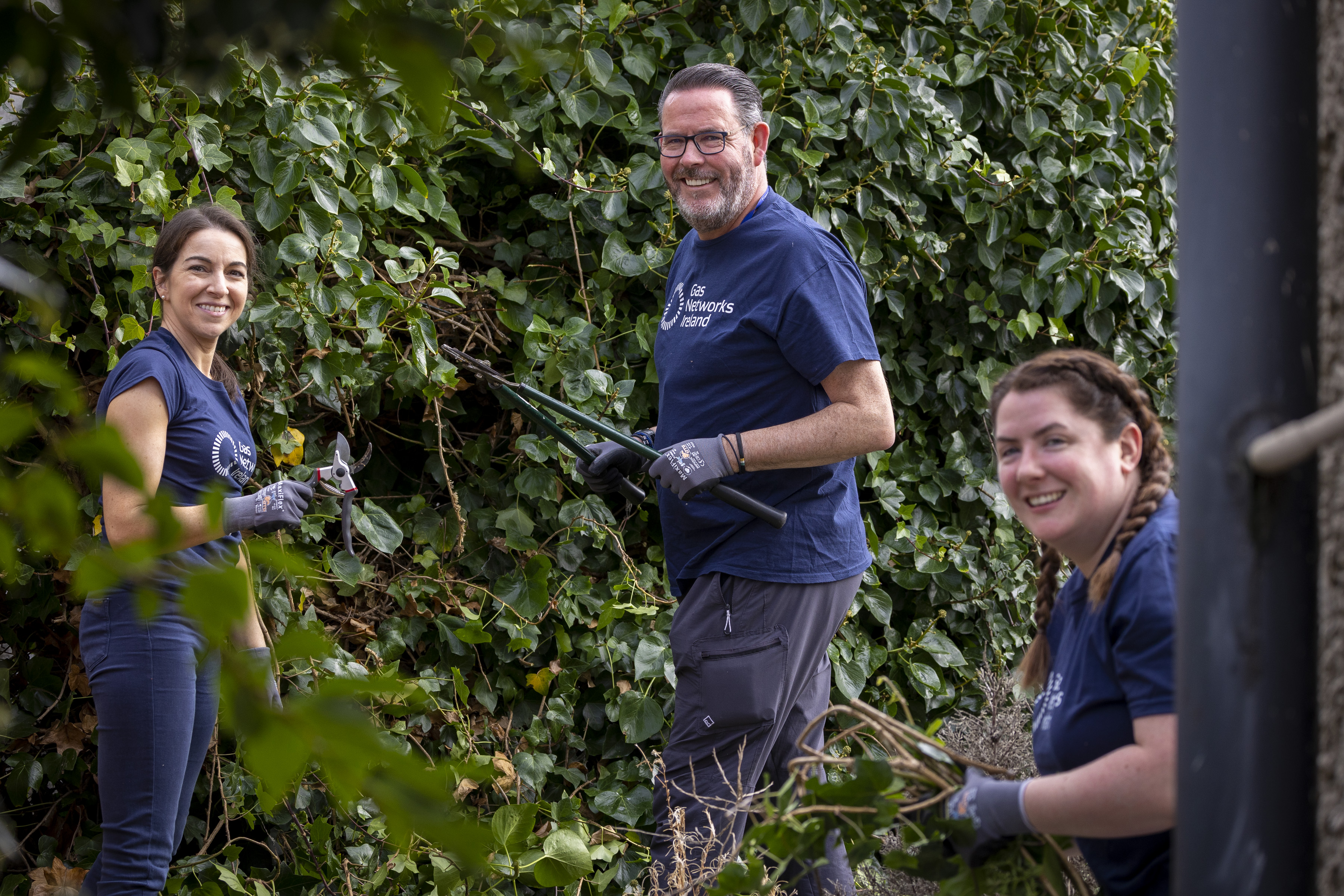 Volunteers tending to an older person's garden 